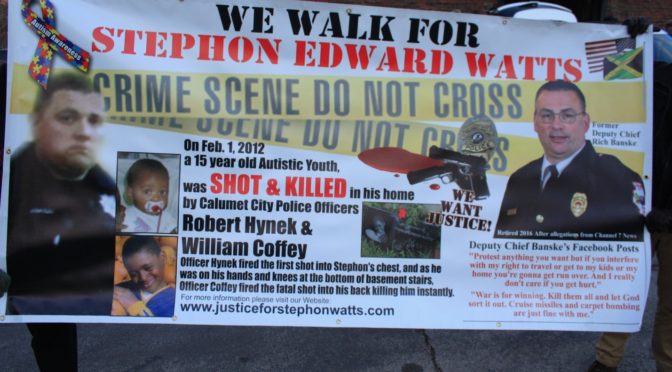 Two people near a building holding a white banner that reads “We Walk for Stephon Edward Watts”. It includes information on how Stephon Watts killed by the police, his pictures, a picture of a gray rectangular tombstone in Watts’ honor, an image of two white, male police officers in black uniforms, background of a crime scene, the Jamaican and American flags (representing Stephon’s heritage), and a ribbon made of puzzle pieces that reads “Autism Awareness.”